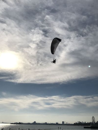 Person paragliding flying against sky