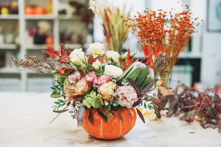 Diy autumn flower arrangement bouquet in pumpkin at floristry studio