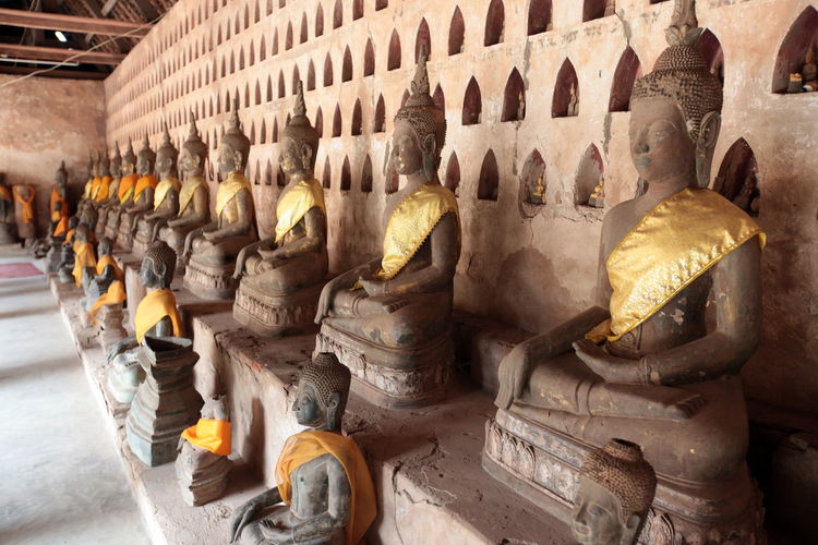 Buddha statues against wall in temple