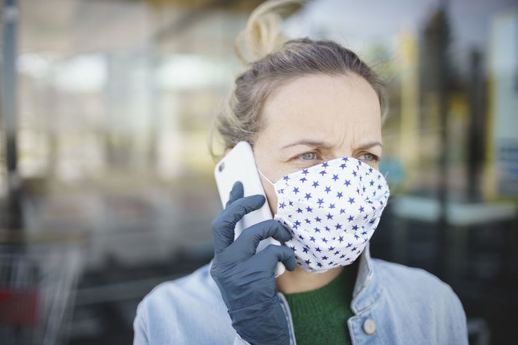 Close-up of woman wearing mask talking on mobile phone outdoors