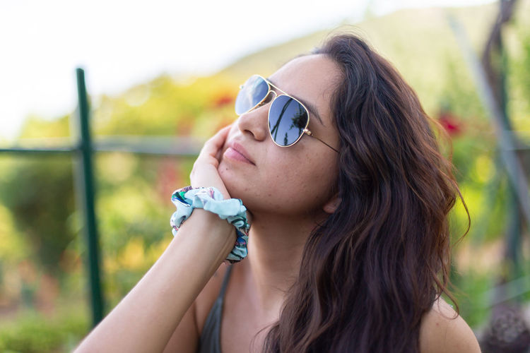 Young woman wearing sunglasses while standing outdoors