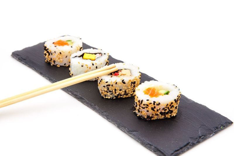 Close-up of sushi served on white background