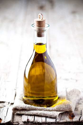 Close-up of glass bottle with olive oil on table