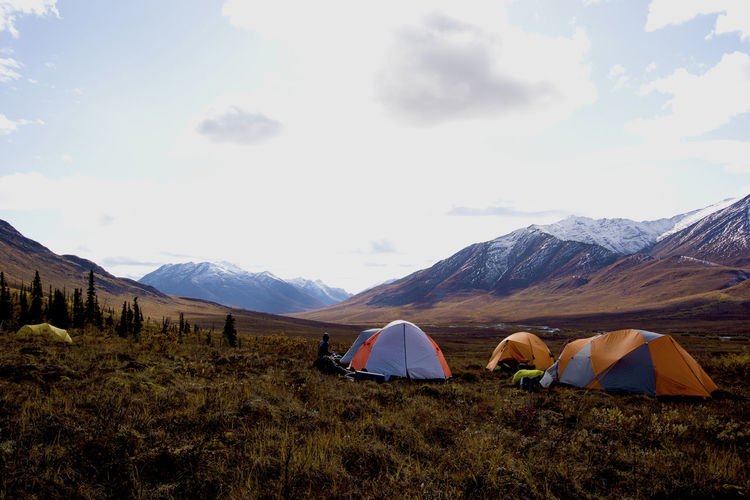Tents on field against mountains