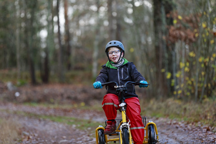 Boy riding bicycle in forest