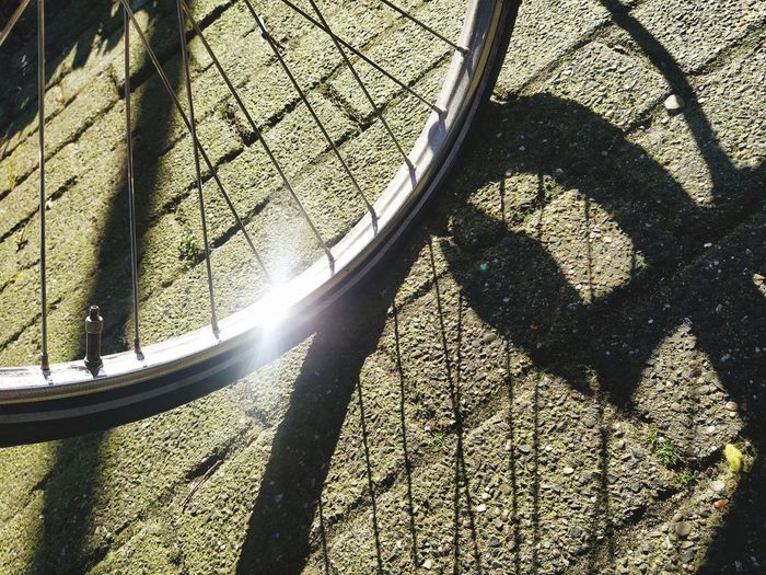 High angle view of bicycle shadow on metal fence