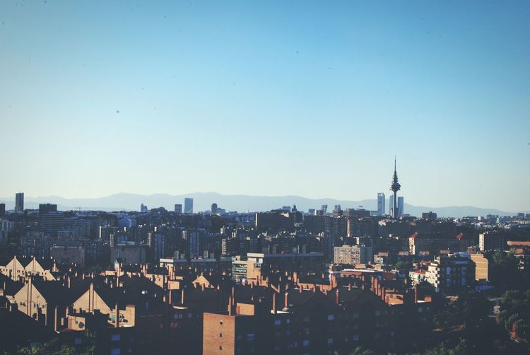 Cityscape against clear blue sky