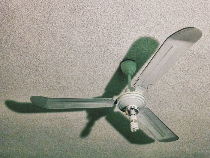 Low angle view of light bulb on ceiling fan