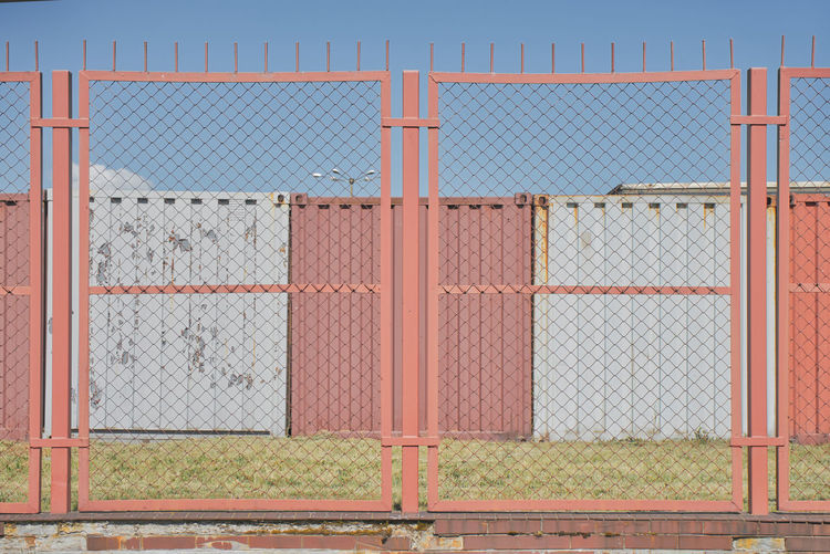 Closed metal fence against blue sky