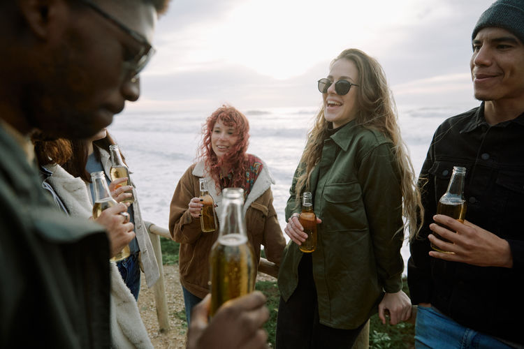 Happy friends enjoying beer at beach