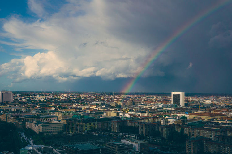 Rainbow over cityscape against sky