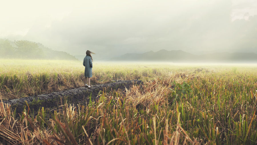 Rear view of woman standing on field