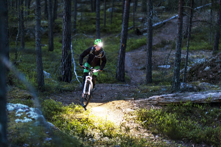 Woman cycling through forest