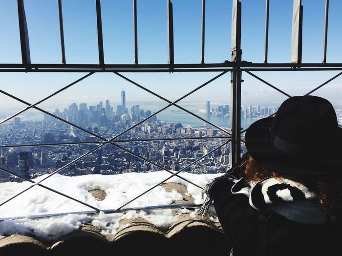 Rear view of woman looking at cityscape from observation point during winter