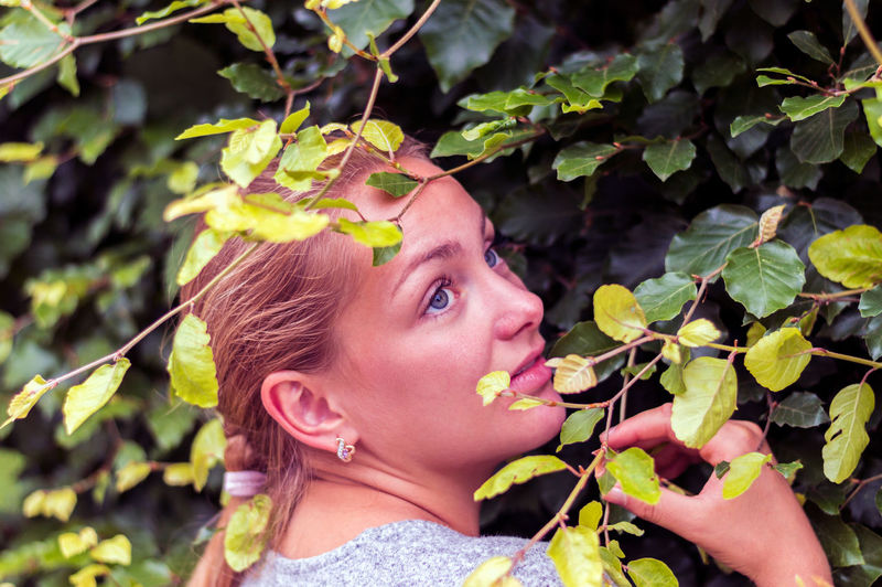 Close-up of young woman against tree