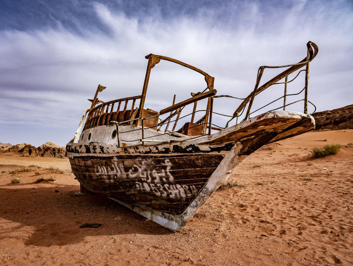 Abandoned ship on beach against sky