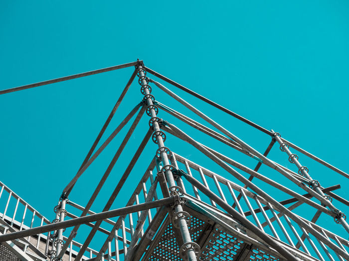 Low angle view of scaffolding against clear blue sky