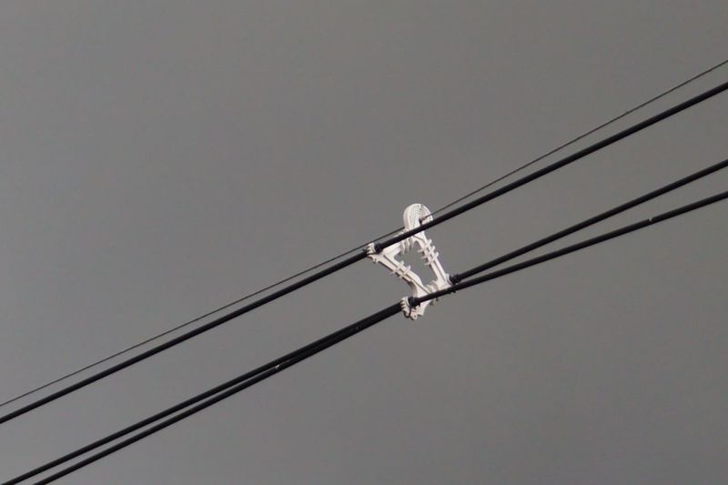 Low angle view of power lines against clear sky