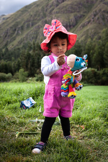 Full length of girl with toy standing on field