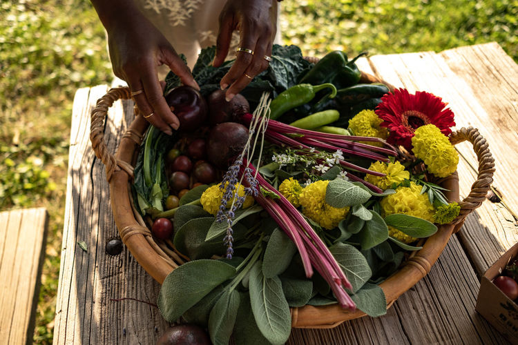 Midsection of man holding vegetables in basket