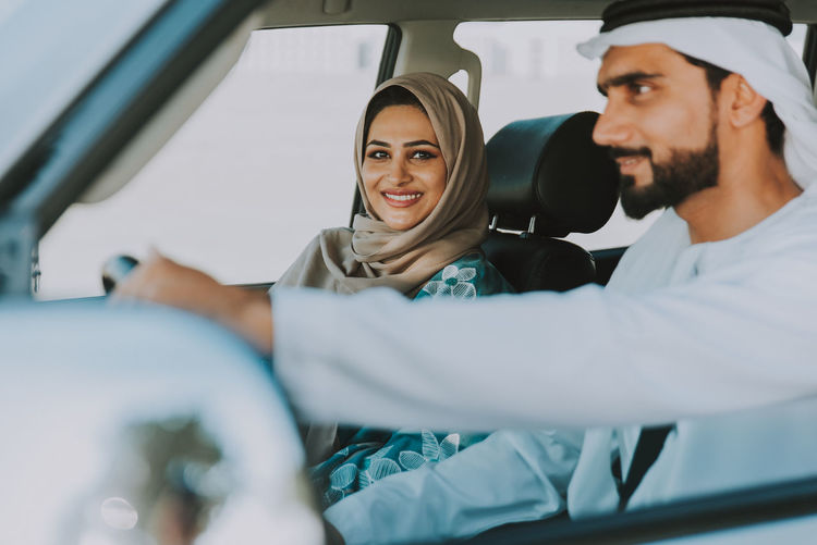 Portrait of smiling woman with husband traveling in car