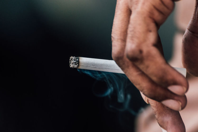 Close-up of person holding cigarette
