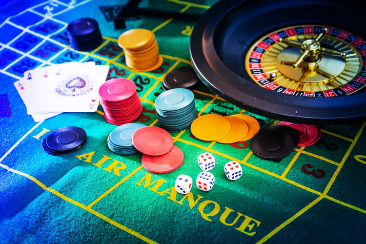 High angle view of gambling chips with cards and dice on table in casino