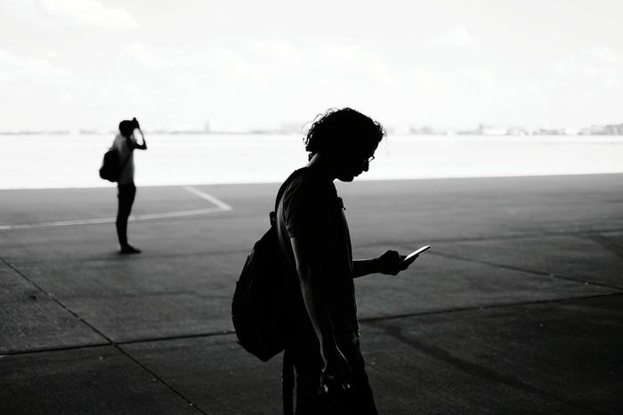 Side view of man using mobile phone at tempelhof airport