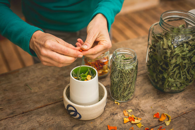Woman prepares organic tea with dried herbs.  mg, brazil.