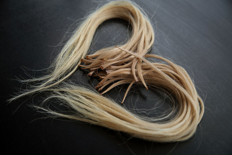 Photo of ready-made keratin-encapsulated strands of light hair for extension.