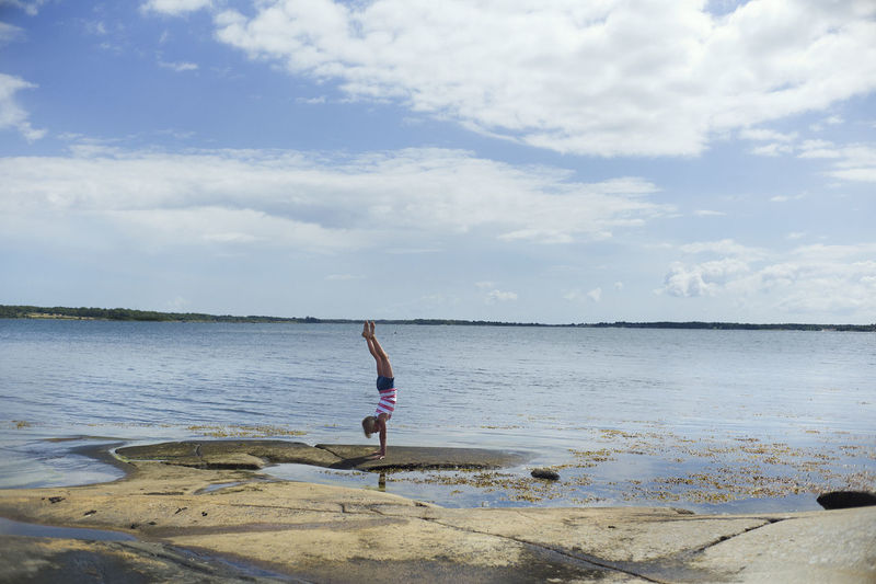 Girl doing handstand at water