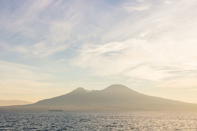 Scenic view of volcano vesuvio and sea against sky during sunset