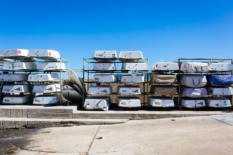 Boats arranged on metal against clear sky