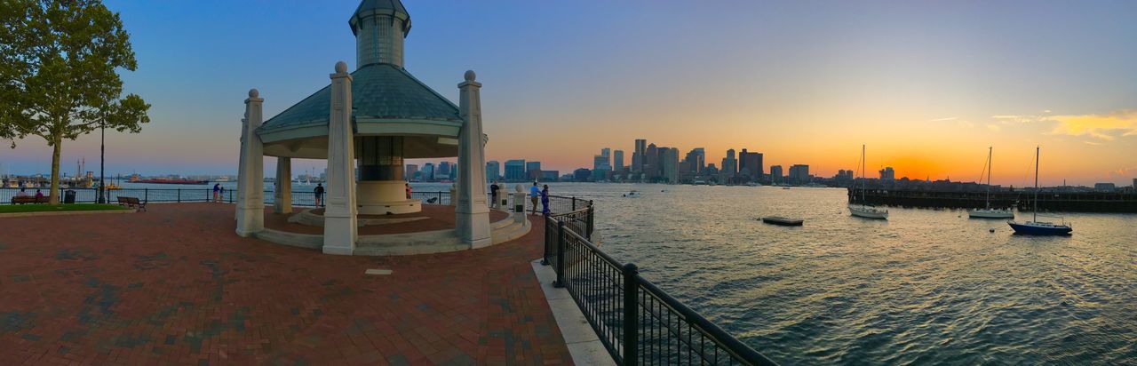 View of buildings at waterfront during sunset