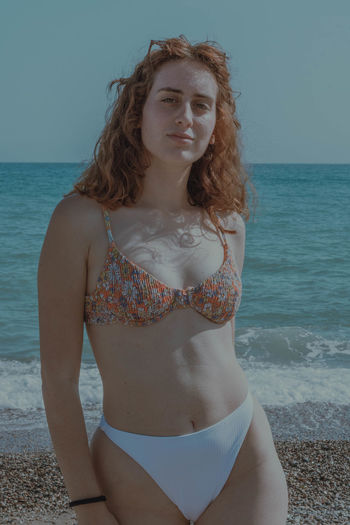 Portrait of young woman standing at beach
