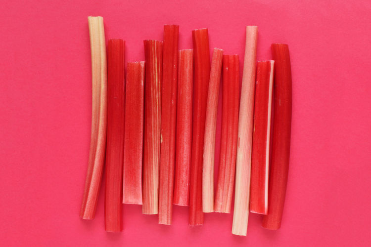 High angle view of colored pencils against pink background