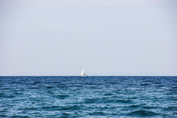 Distant yacht sailing on sea