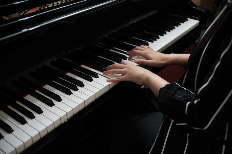 Midsection of woman playing piano