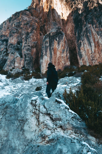Rear view of woman on rock formation during winter