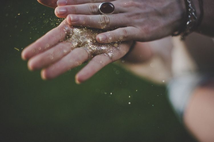 Cropped hands of woman holding glitters