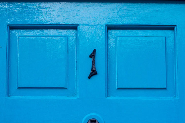 House number 1 on a blue wooden front door in london 
