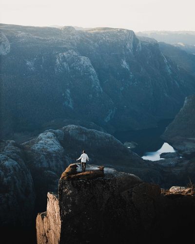 Man sitting on rock by mountain