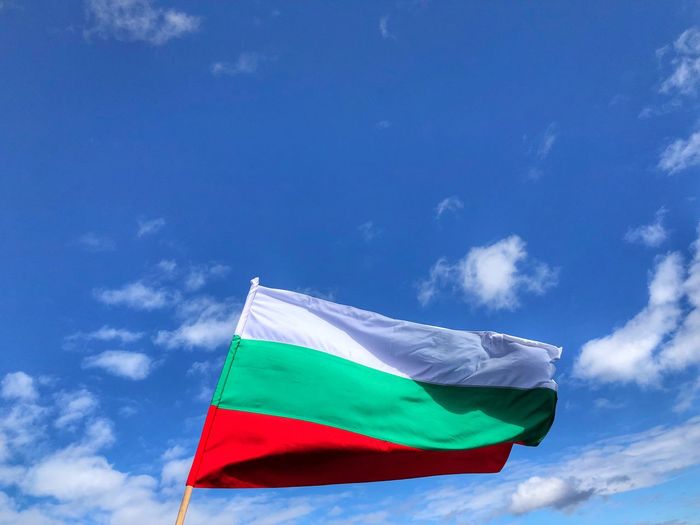 Low angle view of flag waving against sky