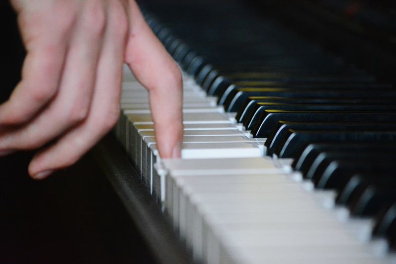 Cropped image of person playing piano
