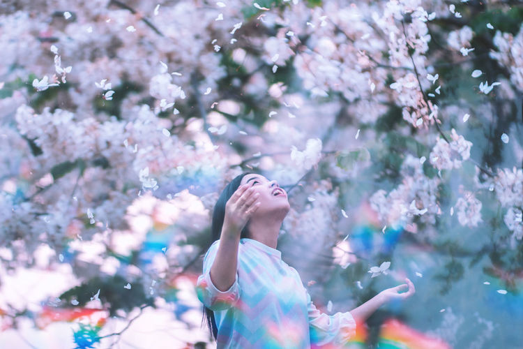 Woman standing on cherry blossom tree
