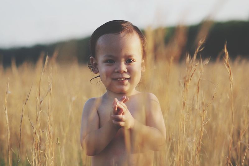 Portrait of smiling boy standing on field