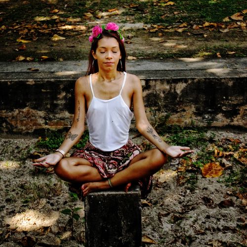 Portrait of a young woman sitting on land