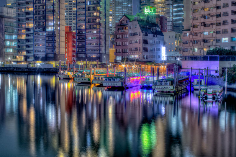 Reflection of buildings in city at waterfront