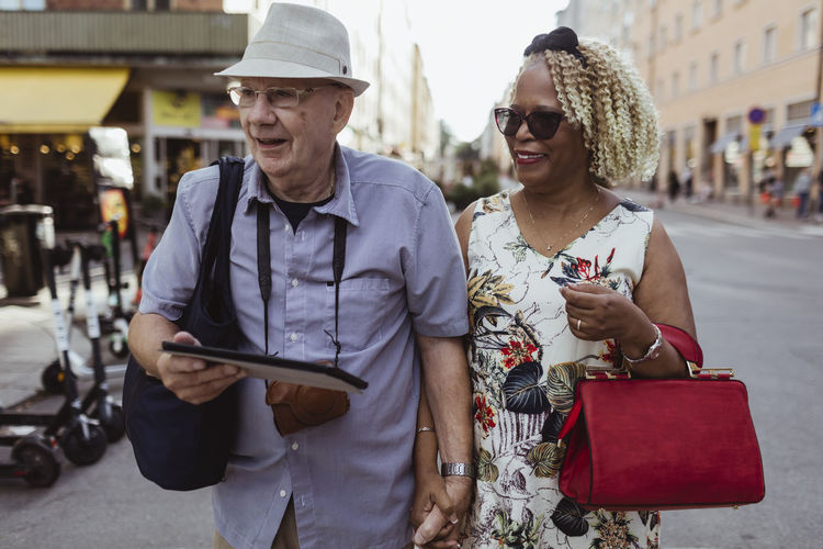 Happy senior couple walking in city