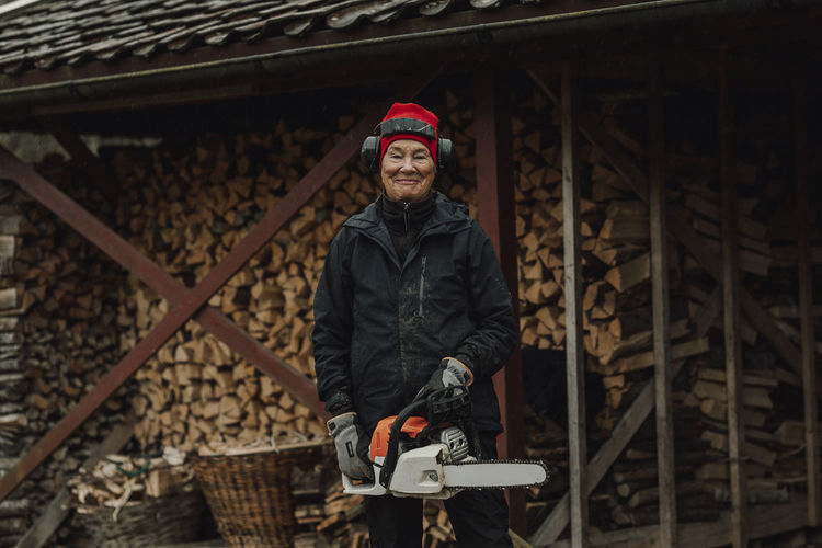 Senior woman holding chainsaw